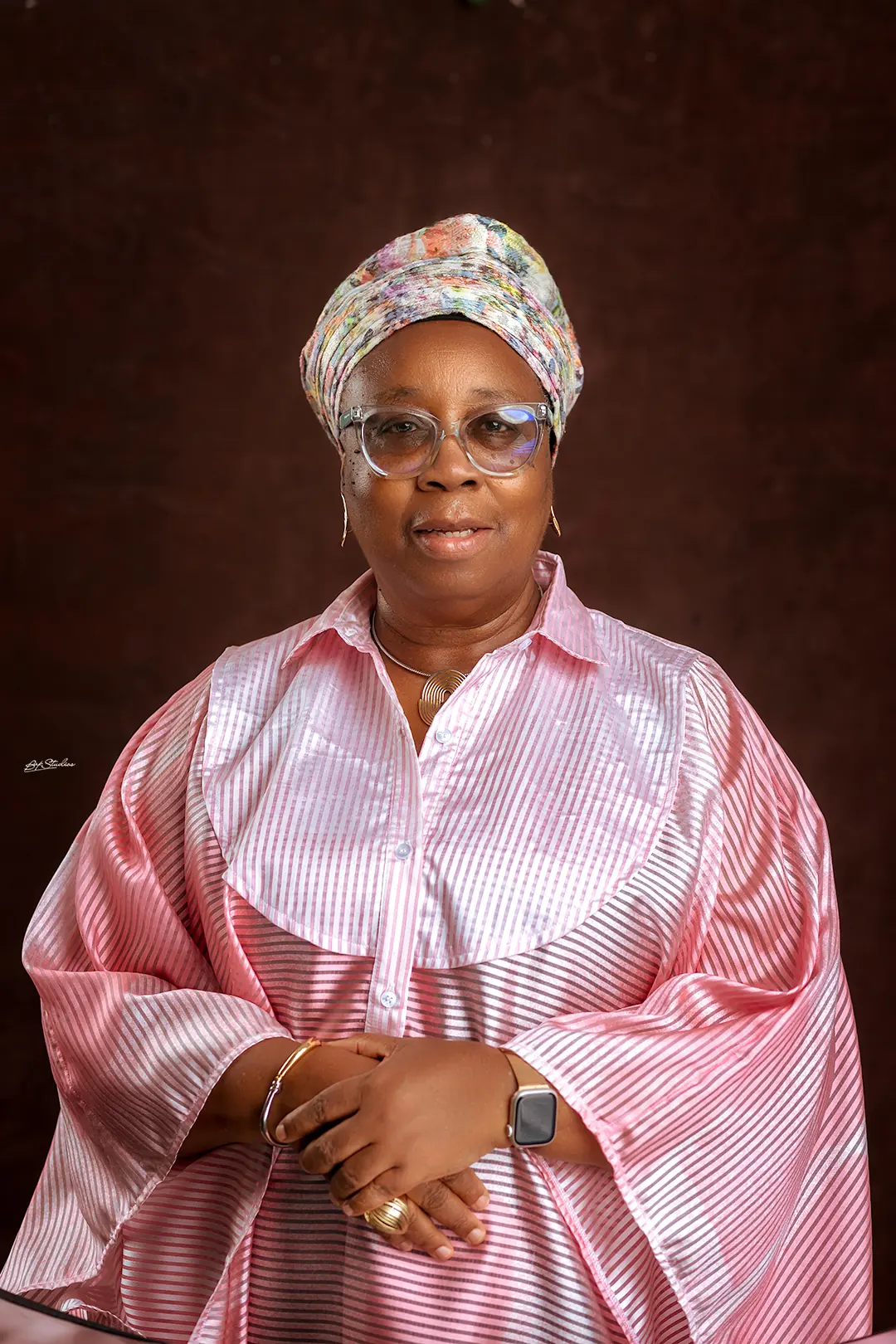 Folasade Adefisayo in a blush-pink striped ensemble with a patterned head-tie.